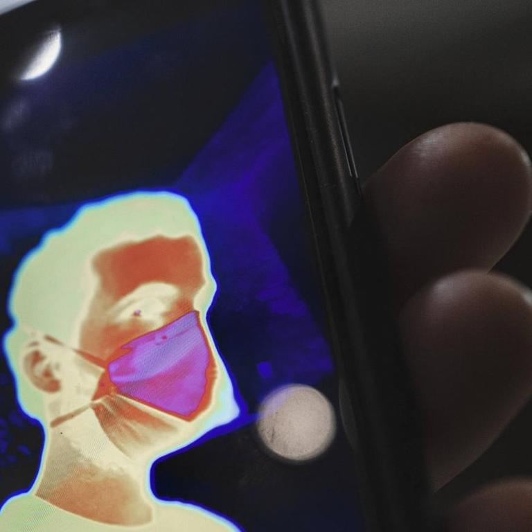 Ein thermisches Selbstporträt mit Maske auf einem Mobiltelefon.