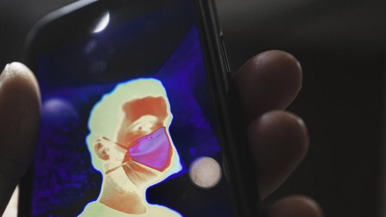Ein thermisches Selbstporträt mit Maske auf einem Mobiltelefon.
