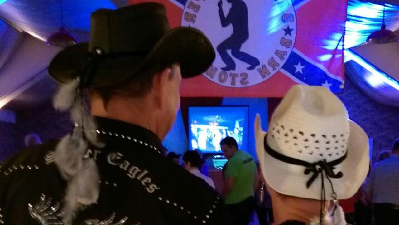 Ein Paar bei einer Line Dance Veranstaltung, mit Cowboy-Hüten auf dem Kopf.