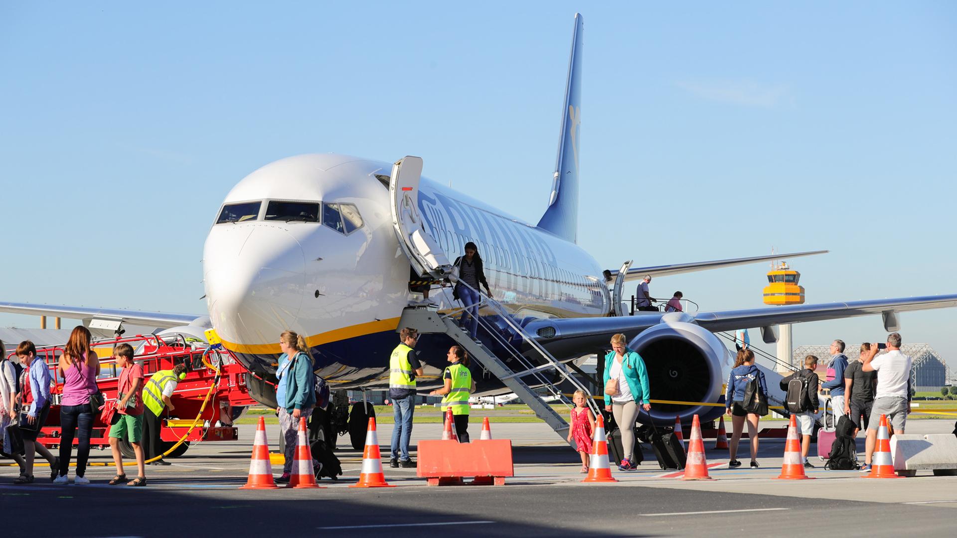 Passagiere und Bodenpersonal vor einer Maschine von Ryanair auf dem Flughafen Hamburg