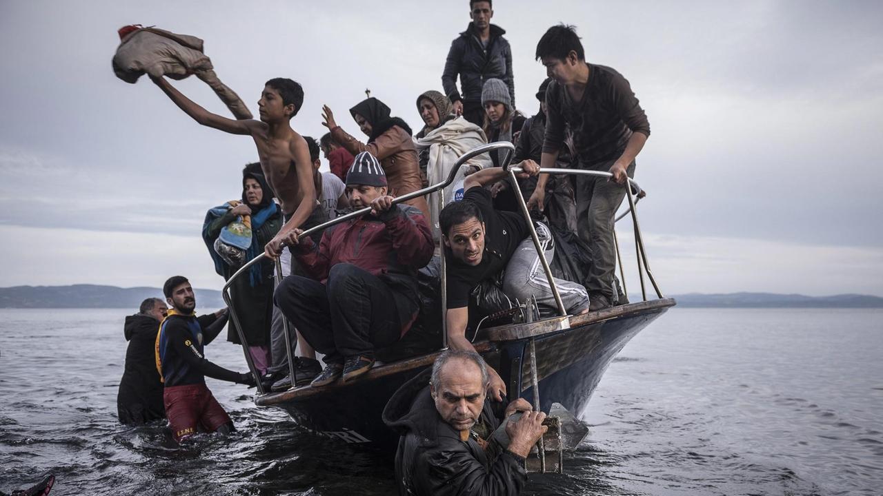 Ein zu sinken drohendes Flüchtlingsboot wird an Land gezogen.