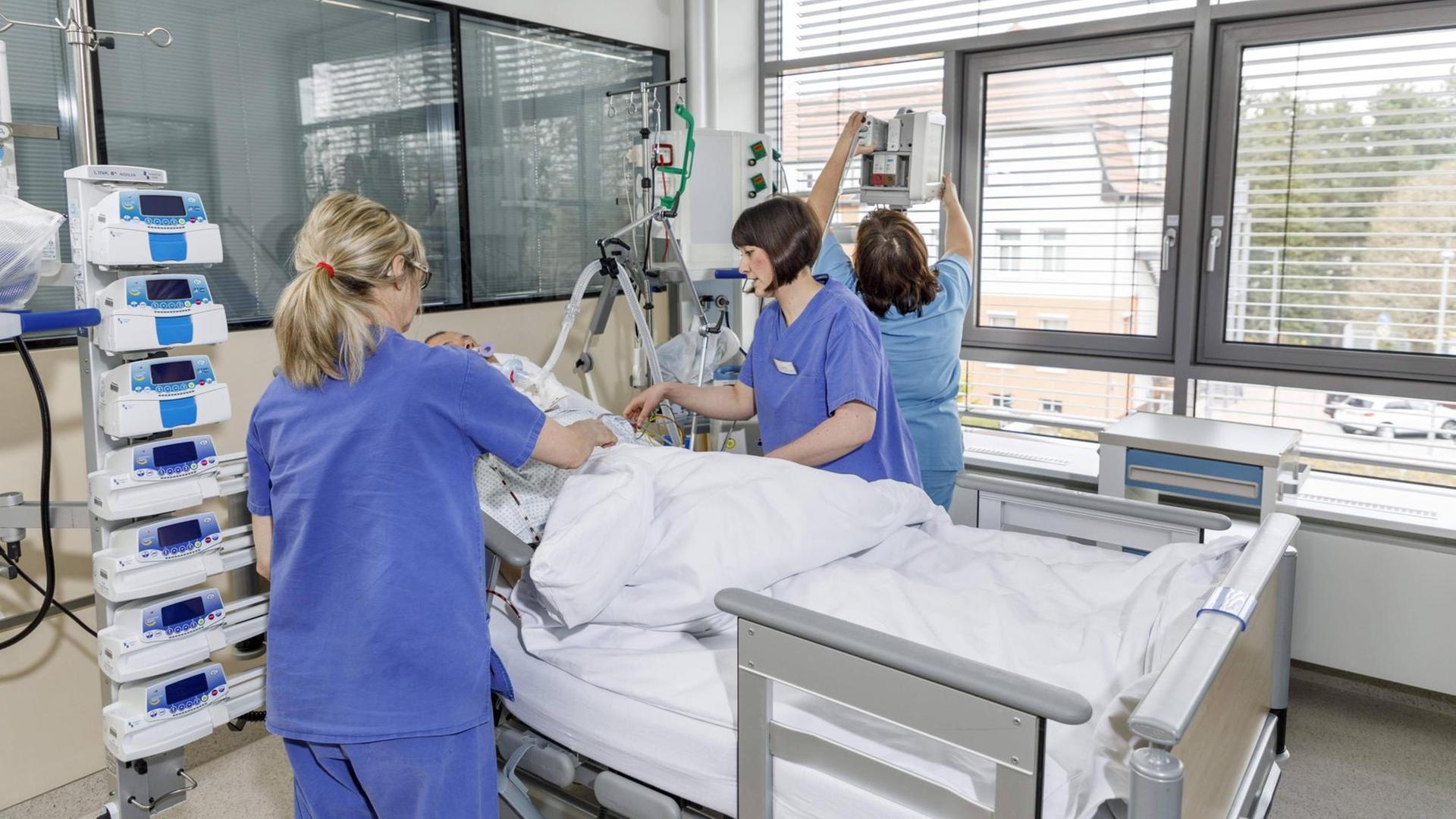 Drei Pflegerinnen am Bett eines Patienten Drei Pflegerinnen am Bett eines Patienten