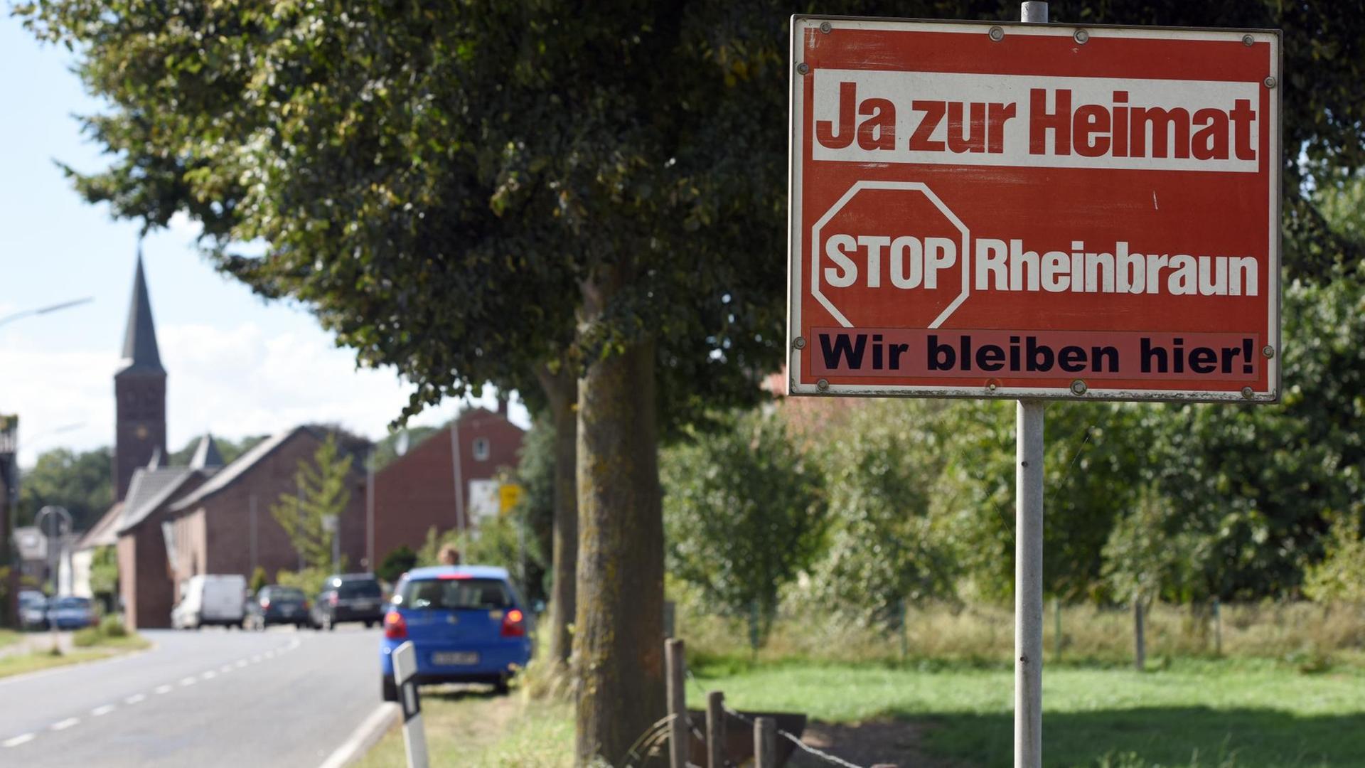 Jahrelang stand dieses Schild am Ortseingang von Keyenberg, bald wird es den Kohlebaggern weichen, so wie die Kirche und Häuser im Hintergrund Jahrelang stand dieses Schild am Ortseingang von Keyenberg, bald wird es den Kohlebaggern weichen, so wie die Kirche und Häuser im Hintergrund