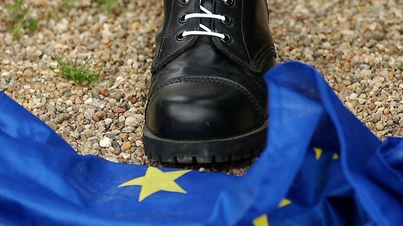 Ein Mitglied der rechtsgerichteten Blut und Ehre-Kulturvereinigung trampelt auf eine Europafahne. Ein Mitglied der rechtsgerichteten Blut und Ehre-Kulturvereinigung trampelt auf eine Europafahne.