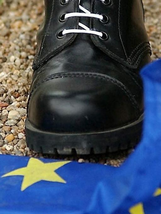 Ein Mitglied der rechtsgerichteten Blut und Ehre-Kulturvereinigung trampelt auf eine Europafahne.