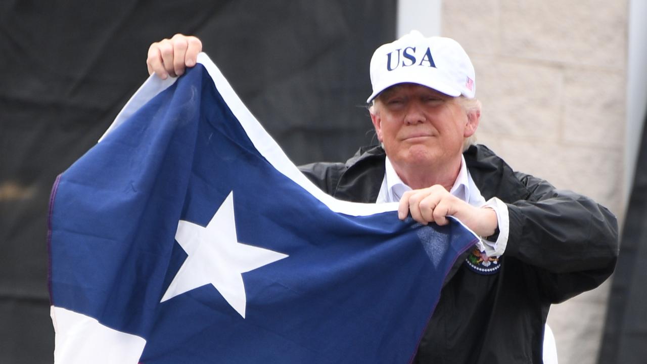 US-Präsident Donald Trump hält bei einem Besuch in Texas die Flagge von Texas hoch.
