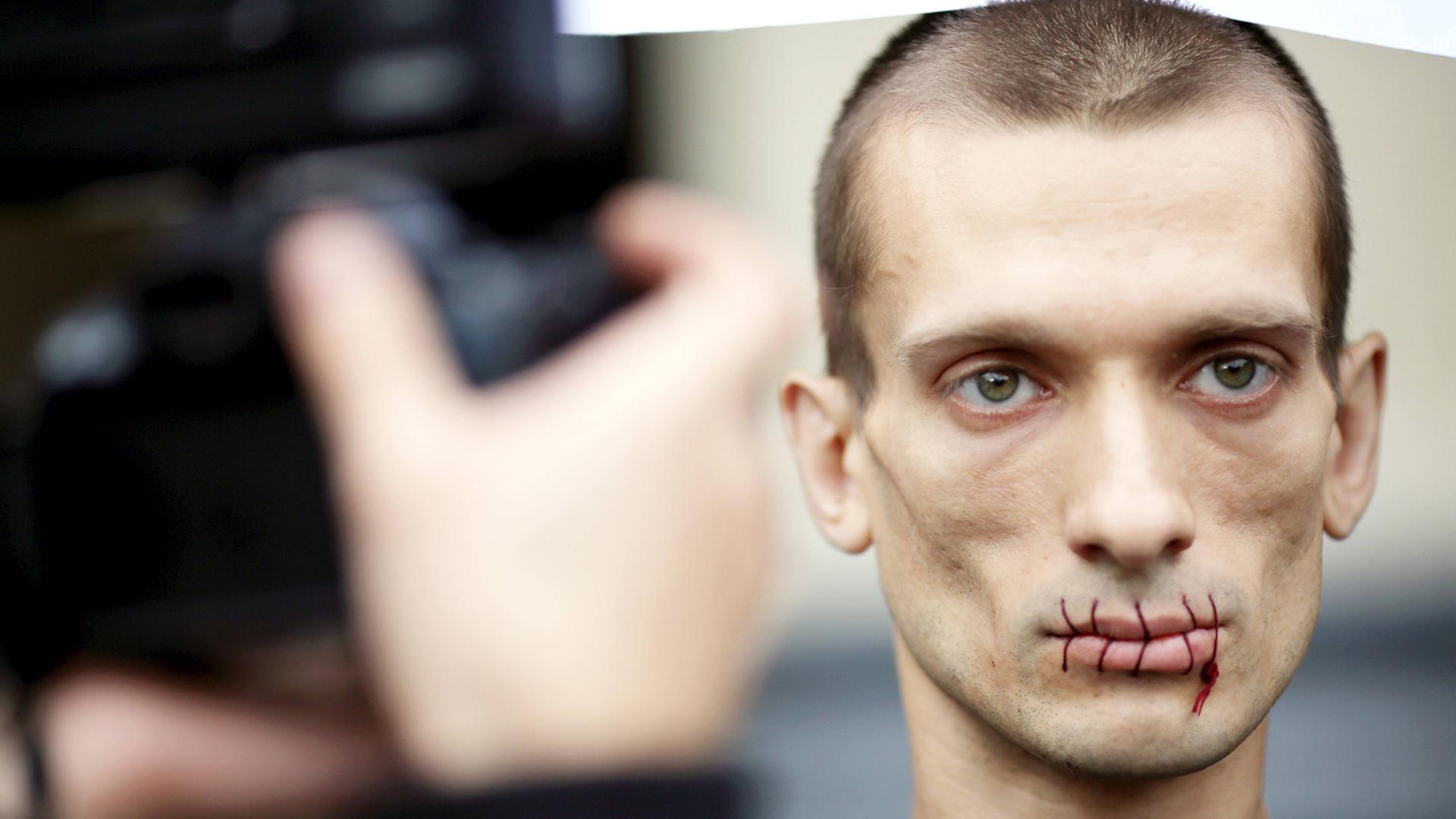 Der russische Aktionskünstler Pjotr Pawlenski protestiert mit zugenähtem Mund im Juli 2012 vor der St. Petersburger Kazan Kathedrale gegen die Verhaftung von Pussy Riot. Der russische Aktionskünstler Pjotr Pawlenski protestiert mit zugenähtem Mund im Juli 2012 vor der St. Petersburger Kazan Kathedrale gegen die Verhaftung von Pussy Riot.