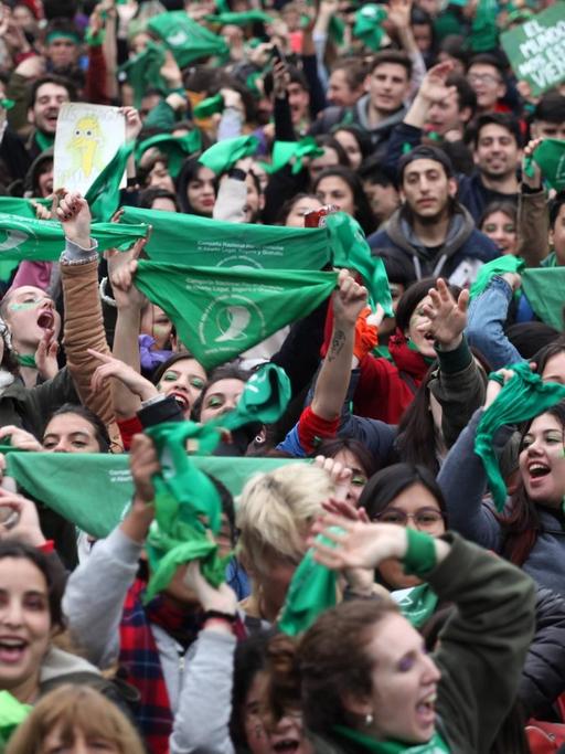 Zum Zeichen ihrer Befüwortung der Legalisierung von Abtreibungen halten viele Menschen grüne Halstücher in die Luft