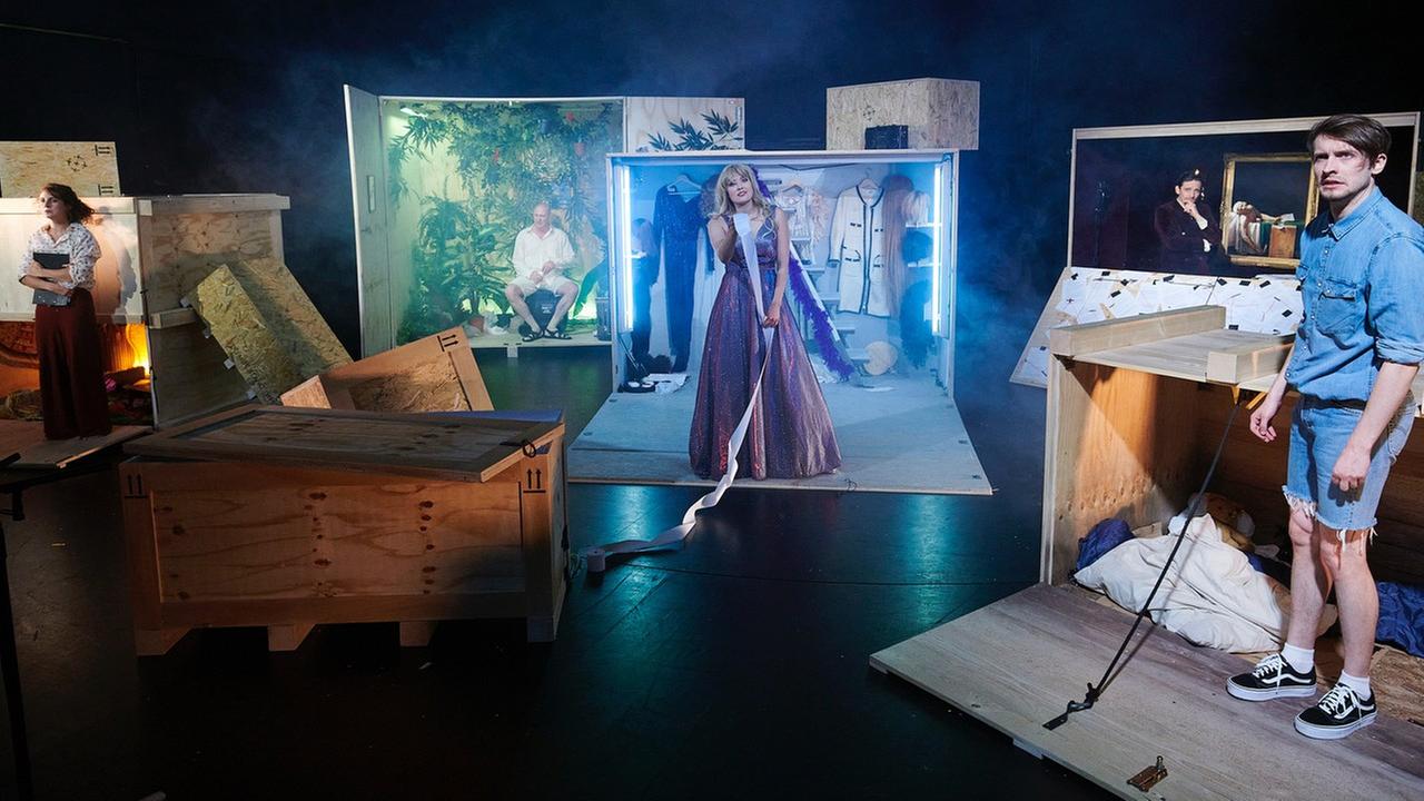 Bühne auf der große Holzcontainer stehen aus denen Schauspieler schauen. Bühne auf der große Holzcontainer stehen aus denen Schauspieler schauen.