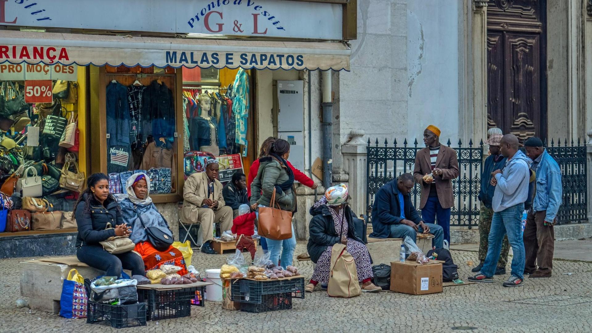 Migranten in Lissabon vor einem Verkaufsstand Migranten in Lissabon vor einem Verkaufsstand