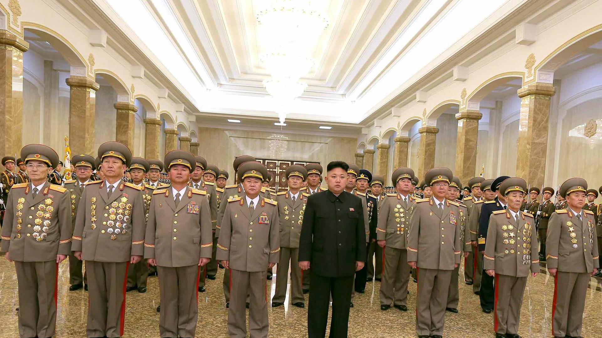 Nordkoreas Diktator Kim Jong-un steht zwischen zahlreichen Uniformträgern im Mausoleum seines Vaters Kim Jong-il Pjöngjang. Nordkoreas Diktator Kim Jong-un steht zwischen zahlreichen Uniformträgern im Mausoleum seines Vaters Kim Jong-il Pjöngjang.