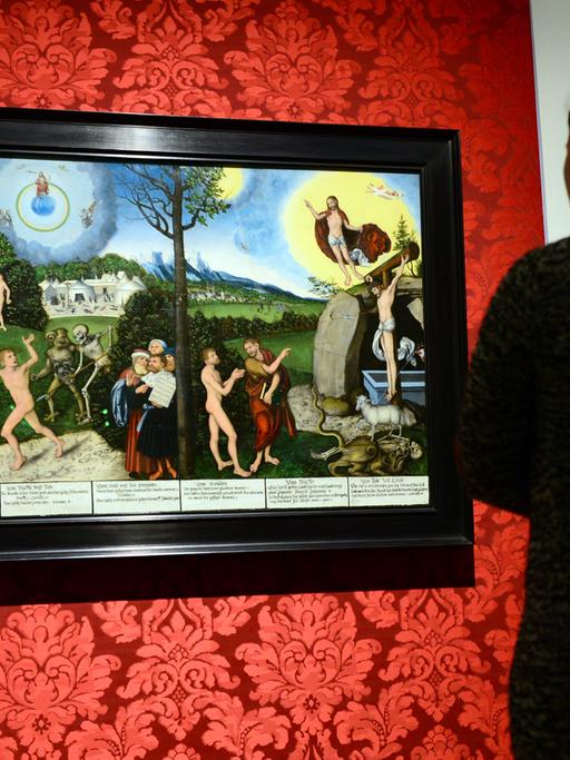 In der Ausstellung "Bild und Botschaft. Cranach im Dienst von Hof und Reformation" betrachten zwei junge Frauen am 26.03.2015 im Herzoglichen Museum in Gotha (Thüringen) das Gemälde "Gesetz und Gnade" von Lucas Cranach d.Ä., gemalt 1529.