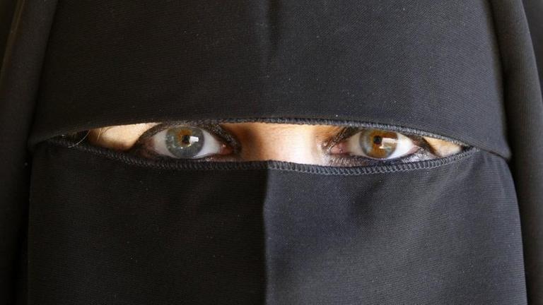 Eine vollverschleierte Muslima mit einem Abaya gekleidet.