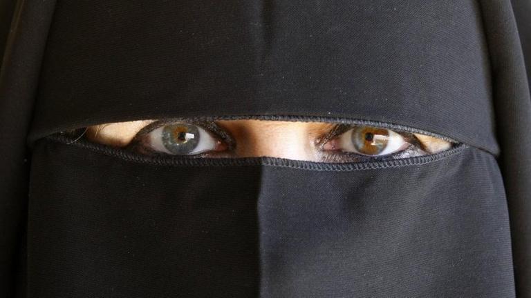 Eine vollverschleierte Muslima mit einem Abaya gekleidet. Eine vollverschleierte Muslima mit einem Abaya gekleidet.