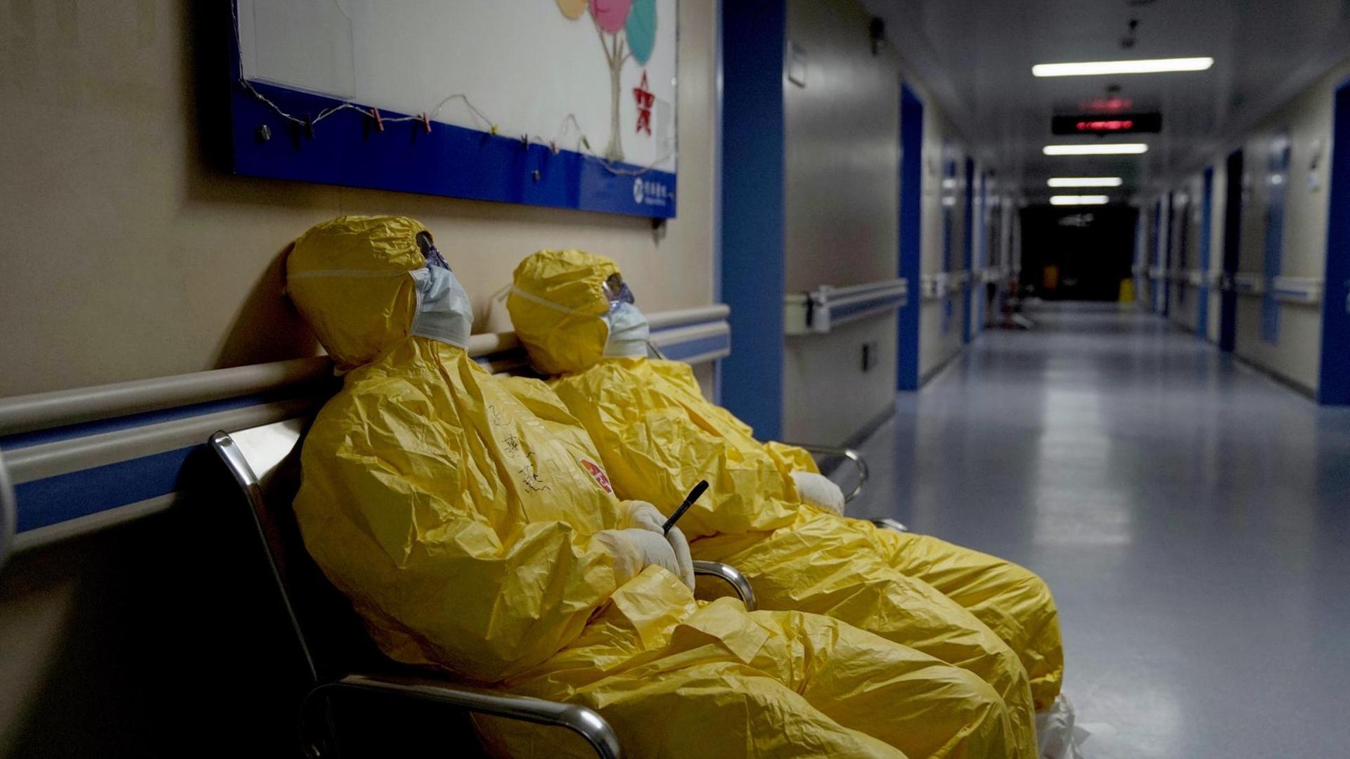 Filmstill aus "76 Days". Zwei Menschen sitzen in Schutzausrüstung auf einem Krankenhausflur. Der Regisseur Hao Wu hat von New York die Arbeit an der Dokumentation "76 Days" über das Leben und Sterben im abgeriegelten Wuhan gestartet. Filmstill aus "76 Days". Zwei Menschen sitzen in Schutzausrüstung auf einem Krankenhausflur. Der Regisseur Hao Wu hat von New York die Arbeit an der Dokumentation "76 Days" über das Leben und Sterben im abgeriegelten Wuhan gestartet.