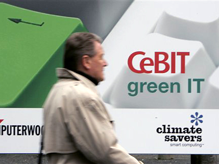Ein Mann geht auf der Computermesse CeBIT in Hannover an einem Plakat mit der Aufschrift "CeBIT green IT" vorbei.