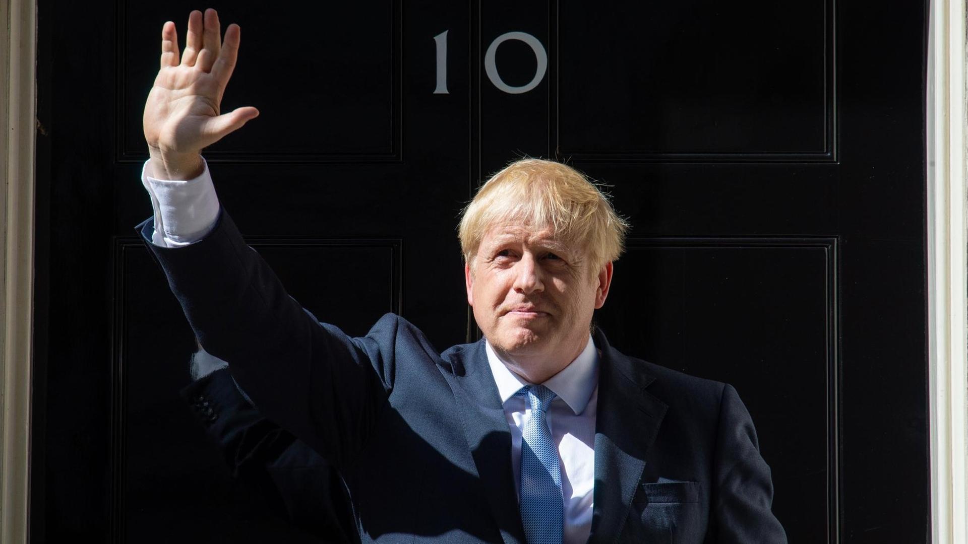 24.07.2019, Großbritannien, London: Boris Johnson, neuer Premierminister von Großbritannien, winkt bei seiner ersten Ansprache als neuer Premierminister vor der 10 Downing Street.