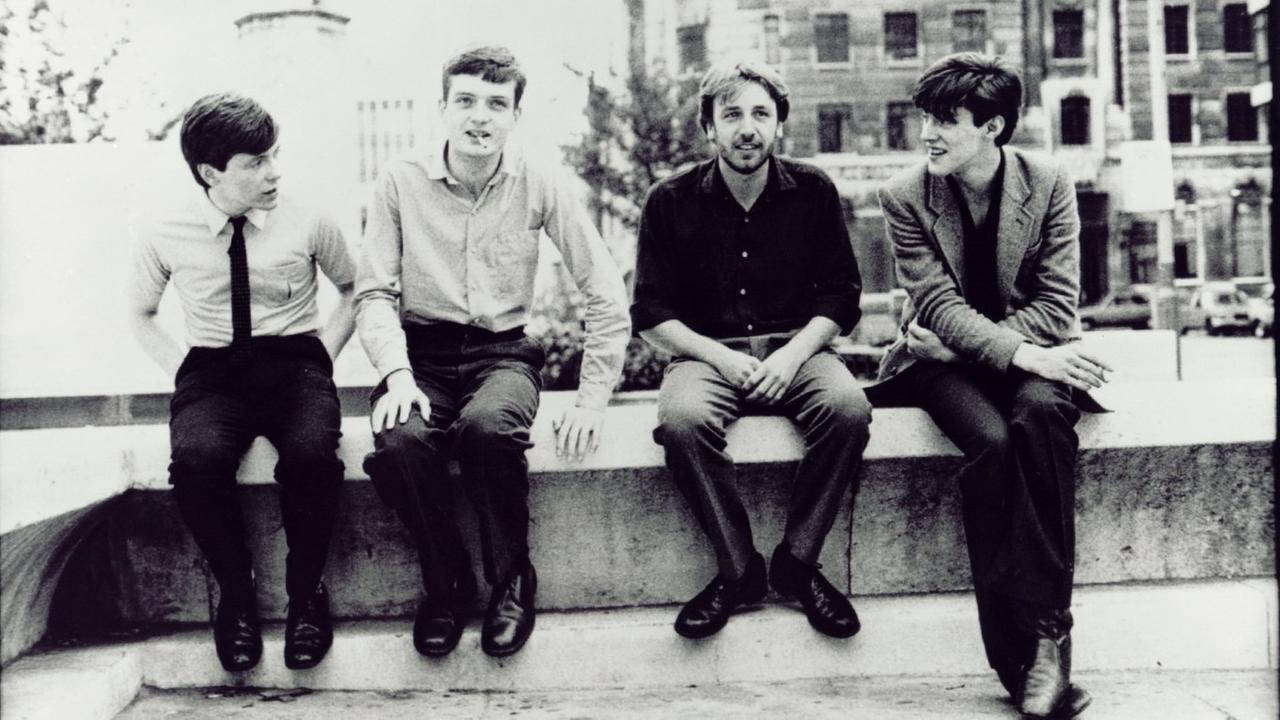 Die Bandmitglieder von Joy Division vereint auf eine Zigarette auf der Bank. Die Bandmitglieder von Joy Division vereint auf eine Zigarette auf der Bank.