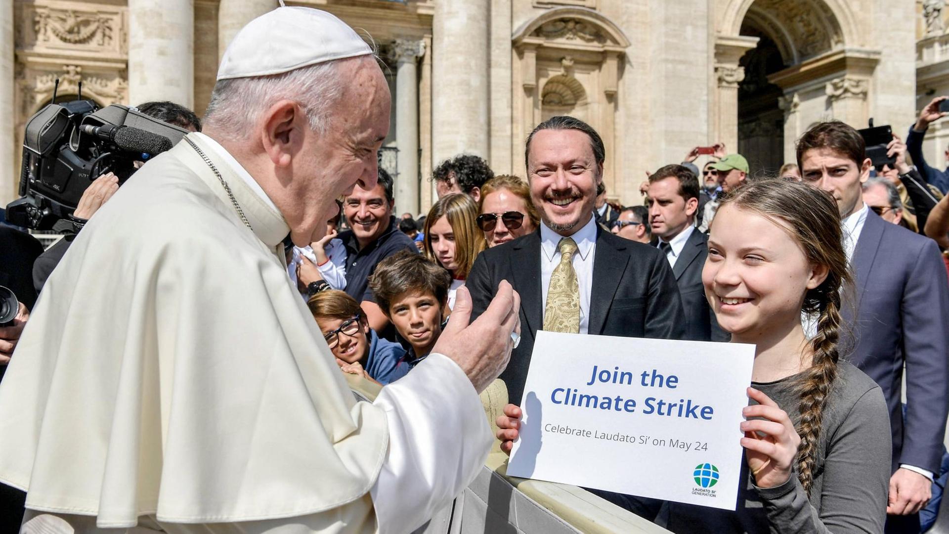 Die schwedische Klimaaktivistin Greta Thunberg steht bei der Generalaudienz des Papstes am 17.4. 2019 in der ersten Reihe und hält Franziskus ein Schild mit der Aufschrift "Join the Climate Strike" entgegen. Die schwedische Klimaaktivistin Greta Thunberg steht bei der Generalaudienz des Papstes am 17.4. 2019 in der ersten Reihe und hält Franziskus ein Schild mit der Aufschrift "Join the Climate Strike" entgegen.