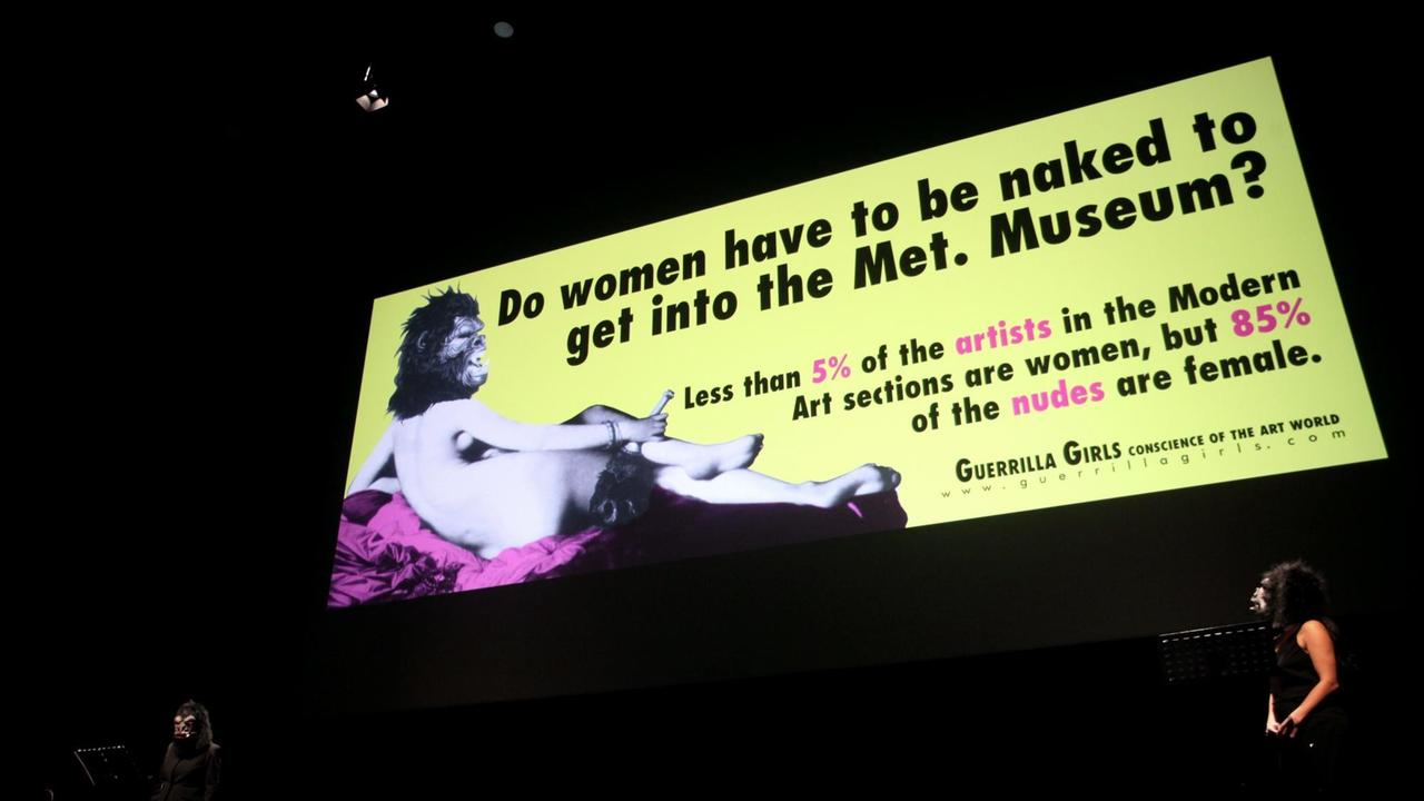 Schild mit der Aufschrift "Do women have to be naked to get into the Met. Museum?" Darauf das Bild einer nackten Frau mit Gorilla Maske. Schild mit der Aufschrift "Do women have to be naked to get into the Met. Museum?" Darauf das Bild einer nackten Frau mit Gorilla Maske.