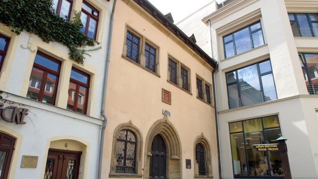Zu sehen ist das angebliche Sterbehaus Luthers in Eisleben mit einem beige-aprikosenfarbenen Anstrich und gothischen Fenstern.