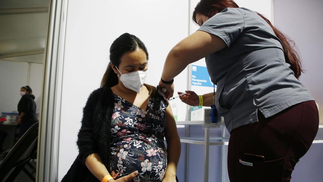 Eine schwangere Frau wird gegen Corona geimpft.
