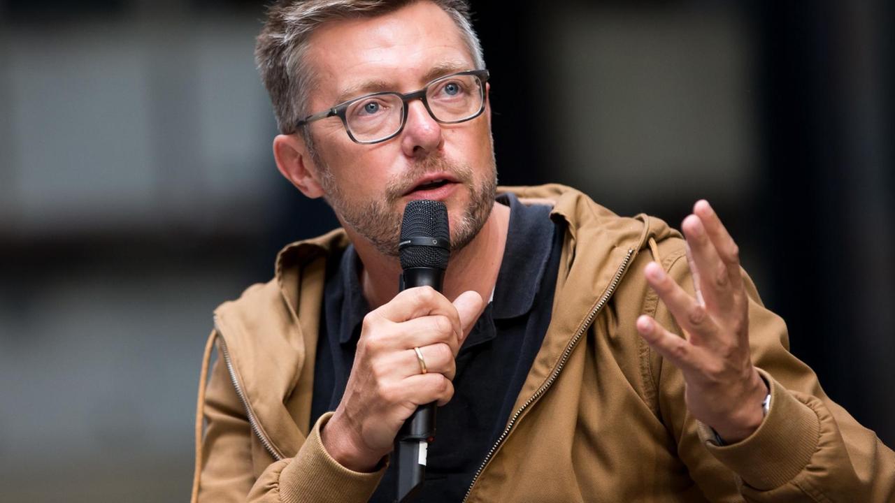 Björn Bicker mit Mikro in der Hand. Björn Bicker mit Mikro in der Hand.