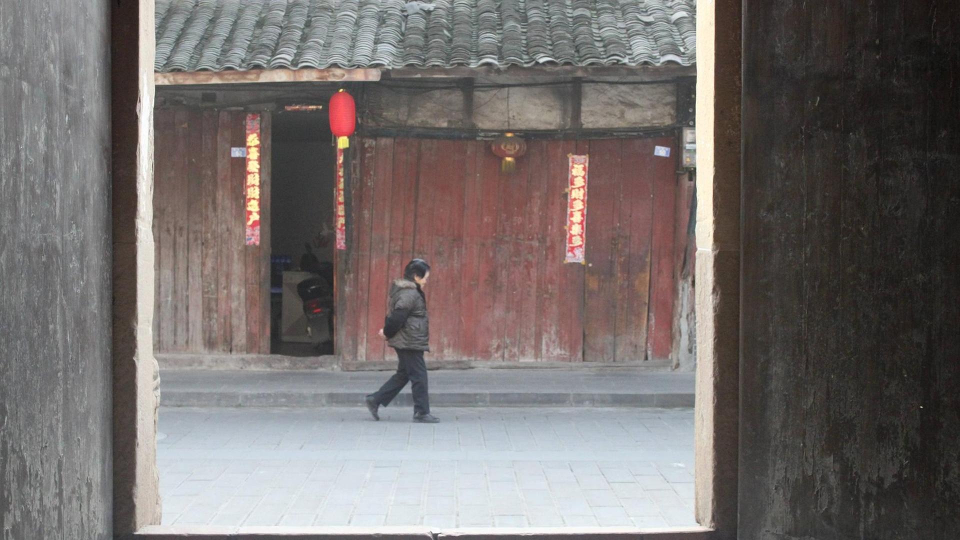 Eine Frau läuft im Januar 2017 eine Straße in der chinesischen Stadt Yuantong, in der Provinz Sichuan entlang. Sie liegt im Südwesten Chinas. Eine Frau läuft im Januar 2017 eine Straße in der chinesischen Stadt Yuantong, in der Provinz Sichuan entlang. Sie liegt im Südwesten Chinas.