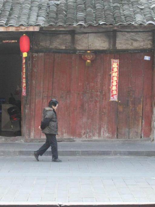 Eine Frau läuft im Januar 2017 eine Straße in der chinesischen Stadt Yuantong, in der Provinz Sichuan entlang. Sie liegt im Südwesten Chinas.