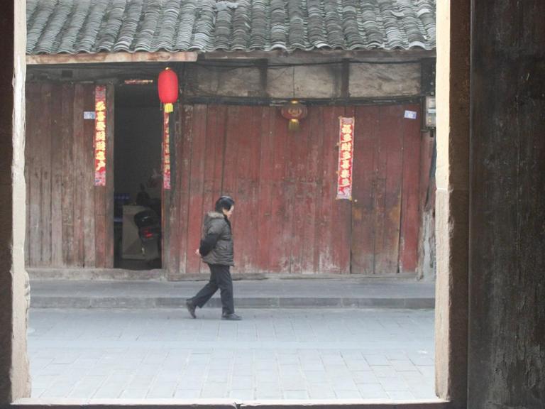 Eine Frau läuft im Januar 2017 eine Straße in der chinesischen Stadt Yuantong, in der Provinz Sichuan entlang. Sie liegt im Südwesten Chinas.