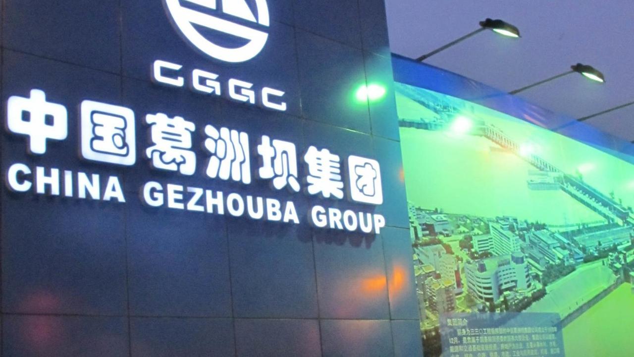 Fußgänger gehen an einem Werbeplakat der China Gezhouba Group vorbei.