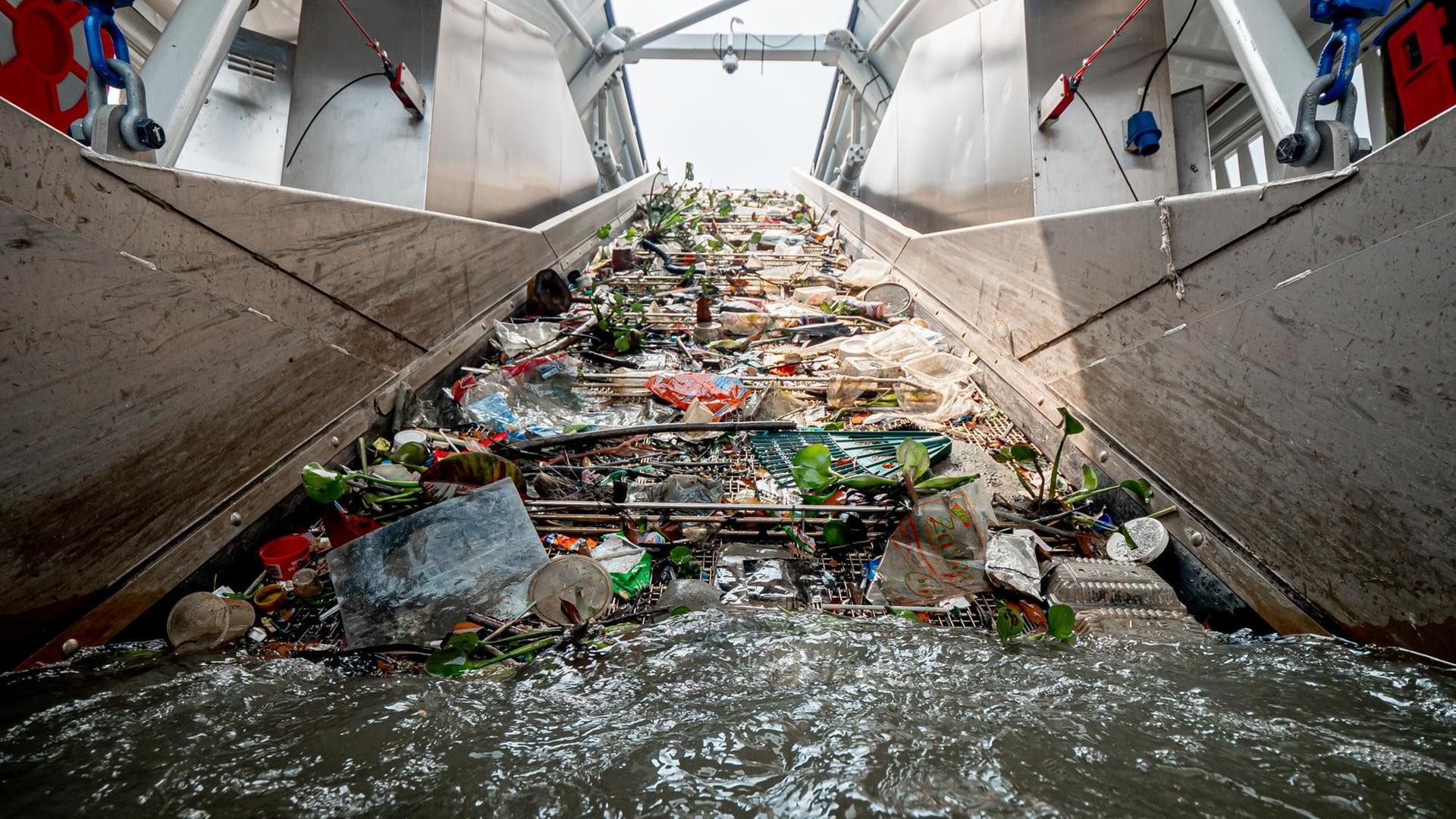 Ein Fließband befördert auf dem Klang River in Malaysia Müll ins Innere des Interceptors. Ein Fließband befördert auf dem Klang River in Malaysia Müll ins Innere des Interceptors.
