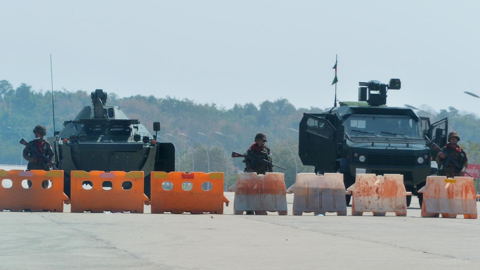 In Myanmar stehen Soldaten an einer Straßen-Sperre. In Myanmar stehen Soldaten an einer Straßen-Sperre.