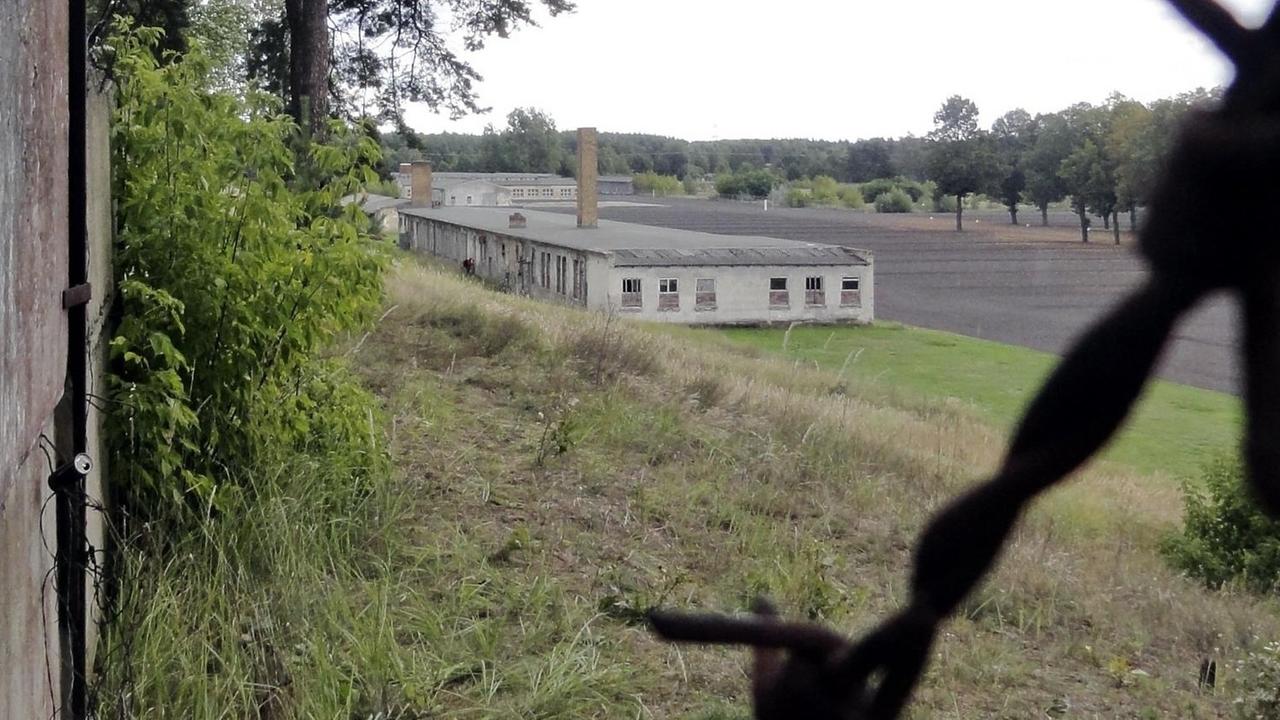Blick über Stacheldraht auf die Gedenkstätte Ravensbrück, 100 Kilometer nördlich von Berlin. Im Hintergrund ist eine der Baracken zu sehen. Das Konzenttrationslager Ravensbrueck (KZ Ravensbrück ) war ein reichsdeutsches Konzentrationslager im damaligen brandenburgischen Templin - Uckermark. Es gilt als das größte Frauenkonzentrationslager des Deutschen Reiches. Blick über Stacheldraht auf die Gedenkstätte Ravensbrück, 100 Kilometer nördlich von Berlin. Im Hintergrund ist eine der Baracken zu sehen. Das Konzenttrationslager Ravensbrueck (KZ Ravensbrück ) war ein reichsdeutsches Konzentrationslager im damaligen brandenburgischen Templin - Uckermark. Es gilt als das größte Frauenkonzentrationslager des Deutschen Reiches.