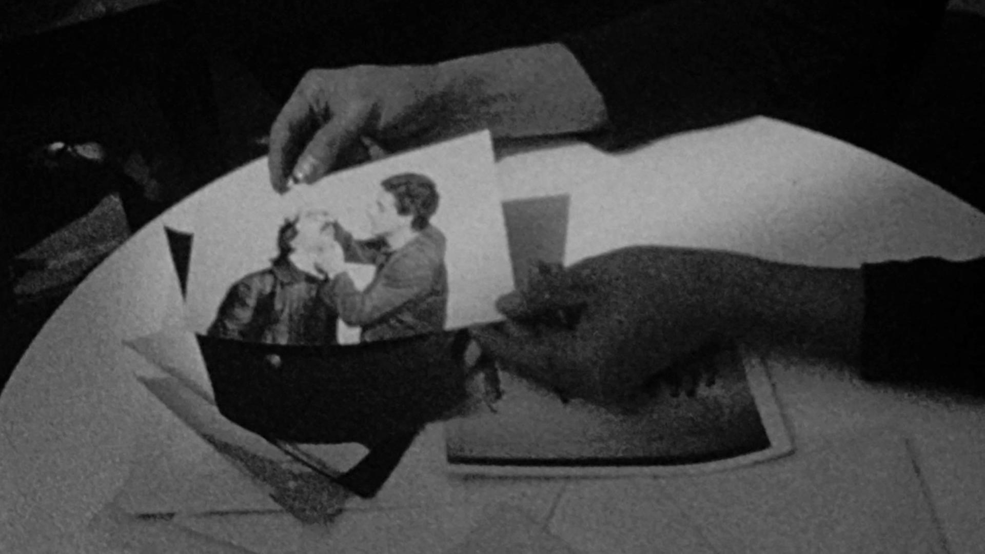 Auf dem Schwarz-Weiß-Filmstill sind die Hände einer Person zu sehen, die ein Foto halten. Courtesy: Cana Bilir-Meier, This Makes Me Want to Predict the Past, 2019 Super 8-Film, digitalisiert, s/w, Ton, 16:02 min