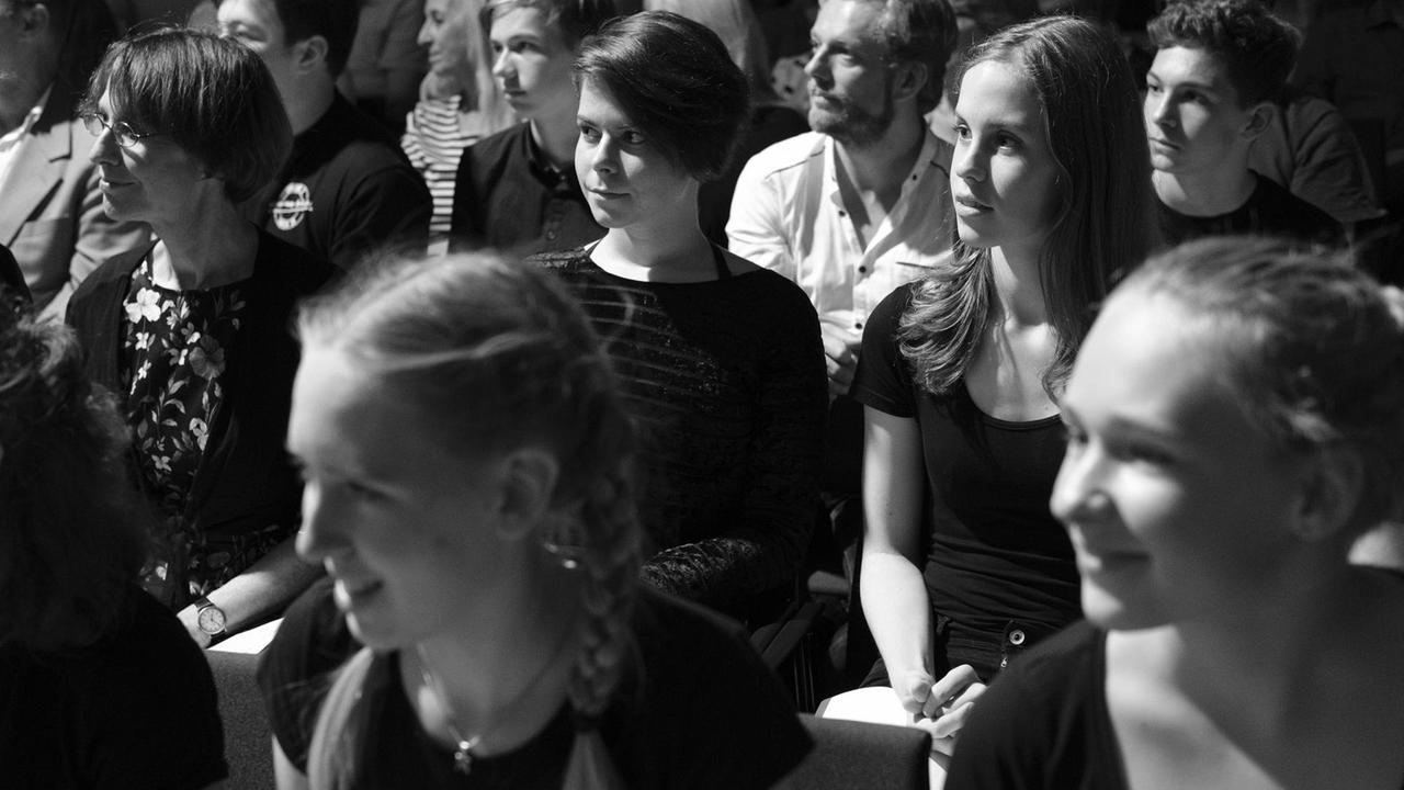 Junge Chormitglieder schauen sitzend sehr aufmerksam in die linke Richtung. Junge Chormitglieder schauen sitzend sehr aufmerksam in die linke Richtung.