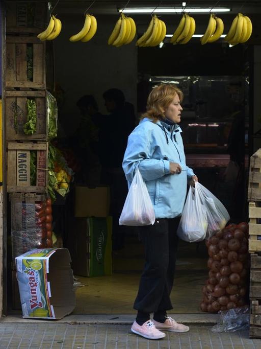Eine Frau steht außerhalb eines Gemüsehändlers in Buenos Aires, Argentinien