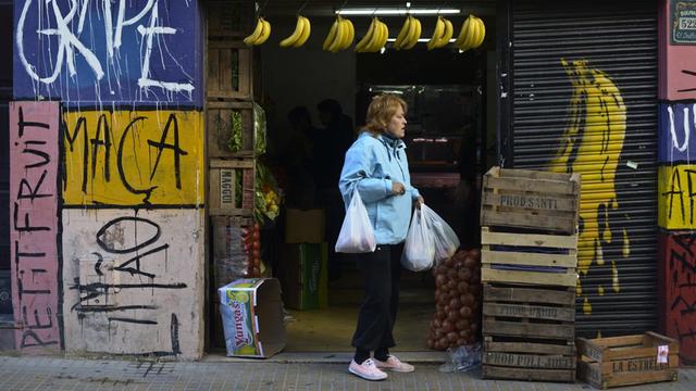 Eine Frau steht außerhalb eines Gemüsehändlers in Buenos Aires, Argentinien