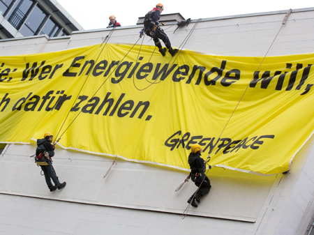 Greenpeace Aktivisten hängen Banner auf: "Wer die Energiewende will, muss auch dafür zahlen"
