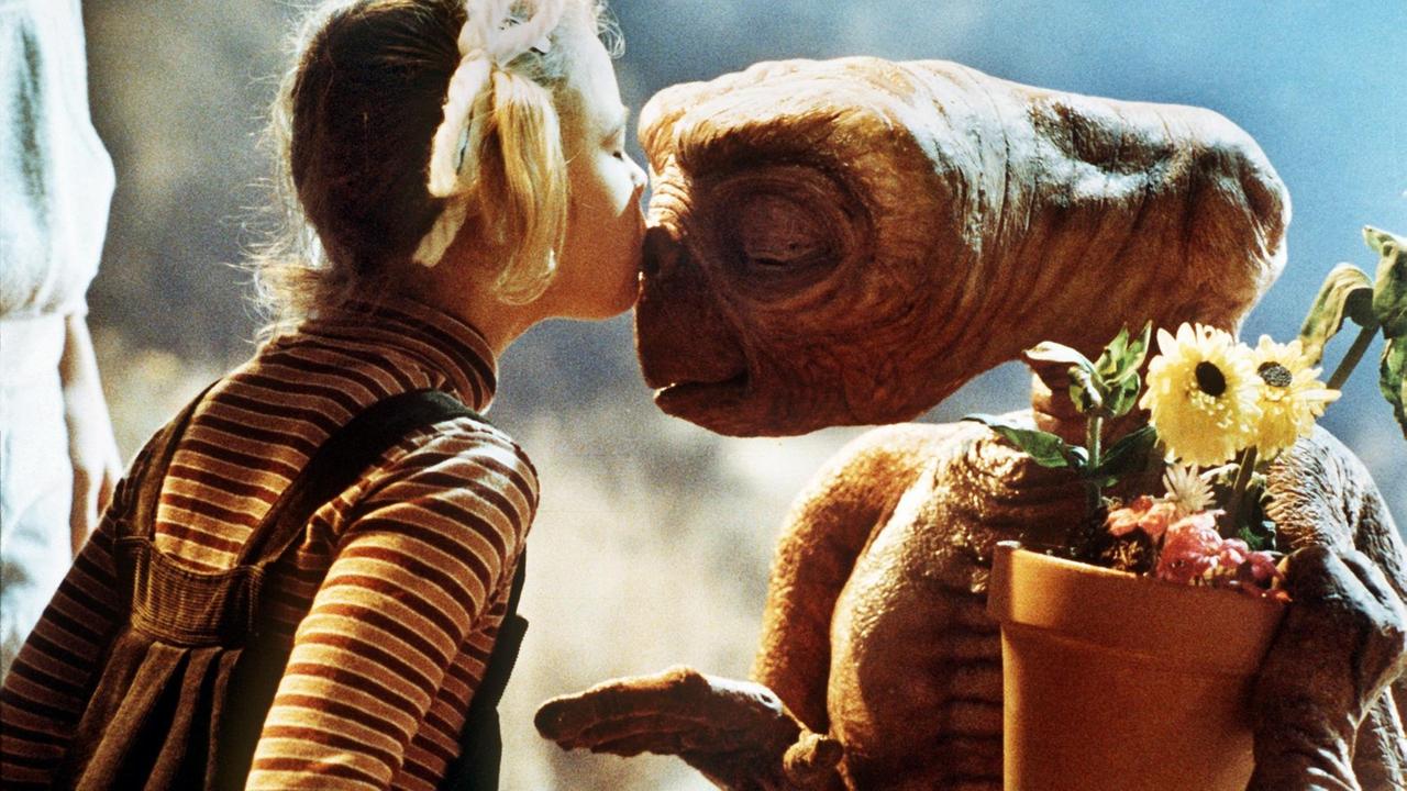 Drew Barrymore (l) als "Gertie" und der Außerirdische "E.T." in einer Szene des gleichnamigen Fantasy-Films von Steven Spielberg. Das kleine Schrumpelwesen von einem fernen Planeten wird aus Versehen von seiner Raumschiff-Besatzung auf der Erde zurückgelassen, freundet sich mit einer Kindergruppe an und stiftet heillose Verwirrung. Sein größter Wunsch, "nach Hause" zurückzukehren, geht nach einem Telefonat mit seinem Heimatplaneten in Erfüllung. "E.T." lief am 9. Dezember 1982 in den deutschen Kinos an und war so erfolgreich, daß er über zehn Jahre Platz eins der Liste der erfolgreichsten Filme anführte. Drew Barrymore (l) als "Gertie" und der Außerirdische "E.T." in einer Szene des gleichnamigen Fantasy-Films von Steven Spielberg. Das kleine Schrumpelwesen von einem fernen Planeten wird aus Versehen von seiner Raumschiff-Besatzung auf der Erde zurückgelassen, freundet sich mit einer Kindergruppe an und stiftet heillose Verwirrung. Sein größter Wunsch, "nach Hause" zurückzukehren, geht nach einem Telefonat mit seinem Heimatplaneten in Erfüllung. "E.T." lief am 9. Dezember 1982 in den deutschen Kinos an und war so erfolgreich, daß er über zehn Jahre Platz eins der Liste der erfolgreichsten Filme anführte.