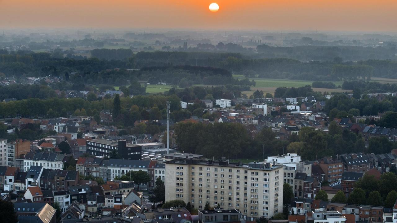 Stadtansicht von Mechelen mit der untergehenden Sonne am Horizont. Stadtansicht von Mechelen mit der untergehenden Sonne am Horizont.