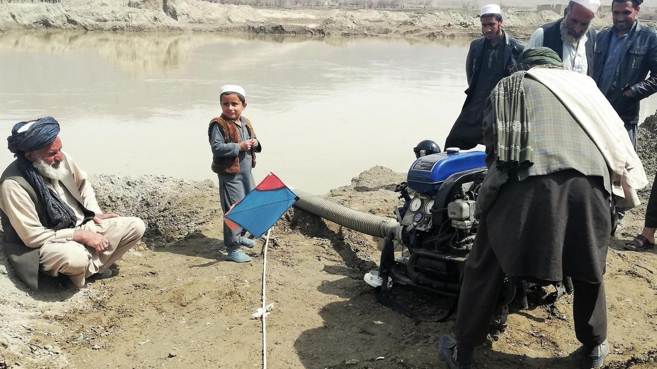 Die Dorfbewohner von Mussahi versuchen eine Wasserpumpe aus Deutschland in Gang zu bringen. Einer drückt, der Rest steht drum herum und guckt. Die Dorfbewohner von Mussahi versuchen eine Wasserpumpe aus Deutschland in Gang zu bringen. Einer drückt, der Rest steht drum herum und guckt.