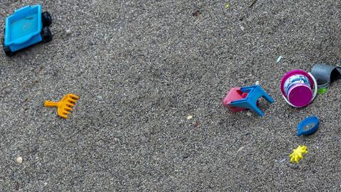 Verstreutes Spielzeug in einem Sandkasten ohne Kinder