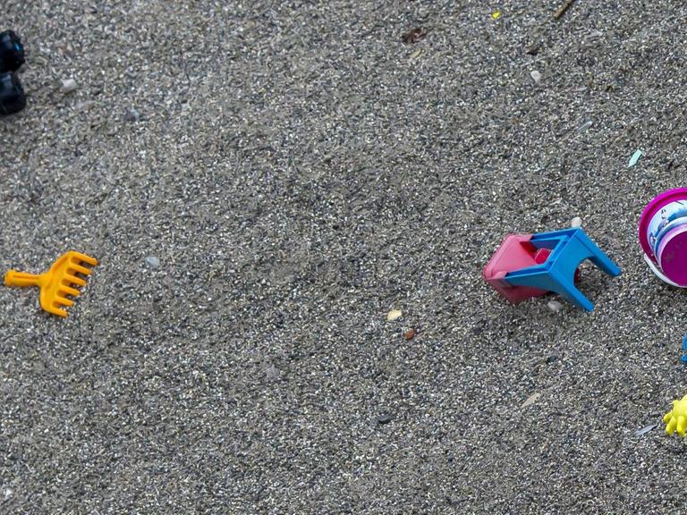 Verstreutes Spielzeug in einem Sandkasten ohne Kinder