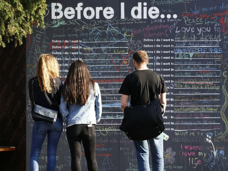 Kunstinstallation in der Konstanzer Fussgängerzone 2016: Passanten konnten aufschreiben, was sie vor dem Tod machen wollen, drei junge Menschen lesen es