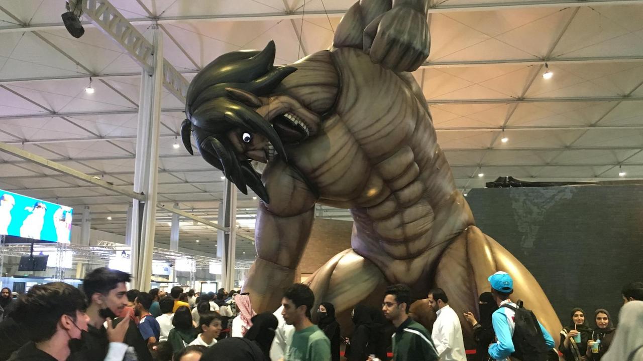 Das Bild zeigt einen Comic-Titanen umringt von Menschen auf der Comic Con in Riad. Das Bild zeigt einen Comic-Titanen umringt von Menschen auf der Comic Con in Riad.