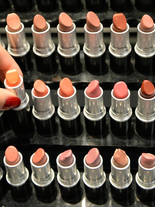 Eine Hand entnimmt am 25.06.2013 in einer Filiale der Parfümeriekette Douglas in Frankfurt am Main (Hessen) einen Lippenstift aus einem Regal.