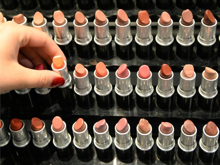 Eine Hand entnimmt am 25.06.2013 in einer Filiale der Parfümeriekette Douglas in Frankfurt am Main (Hessen) einen Lippenstift aus einem Regal.