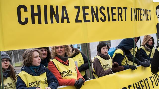 Demonstranten von Amnesty International protestieren am 15.03.2015 vor dem HCC in Hannover (Niedersachsen) gegen die Zensur des Internets in China. China ist Partnerland der CeBIT 2015. Die weltweit größte Computermesse wird am 15.03.2015 in Hannover eröffnet. Foto: Ole Spata/dpa |