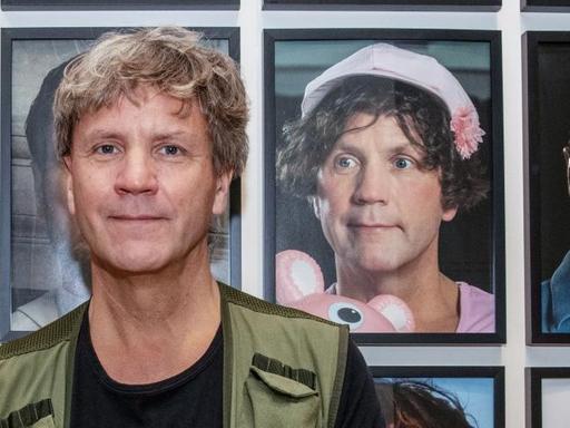 Der Künstler Björn Melhus sitzt am 23.8.2019 im Berliner Max-Liebermann-Haus vor einer Installation mit Selbstbildnissen. Sie sind Bestandteil der Ausstellung «HOT SET», die vom 2 Foto: Paul Zinken/dpa | Verwendung weltweit